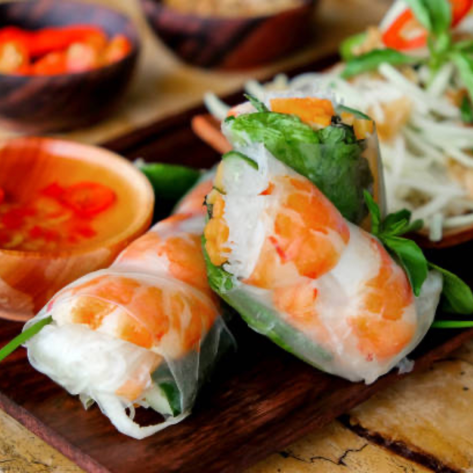 Fresh Vietnamese spring rolls with shrimp and vegetables, served with a dipping sauce.
